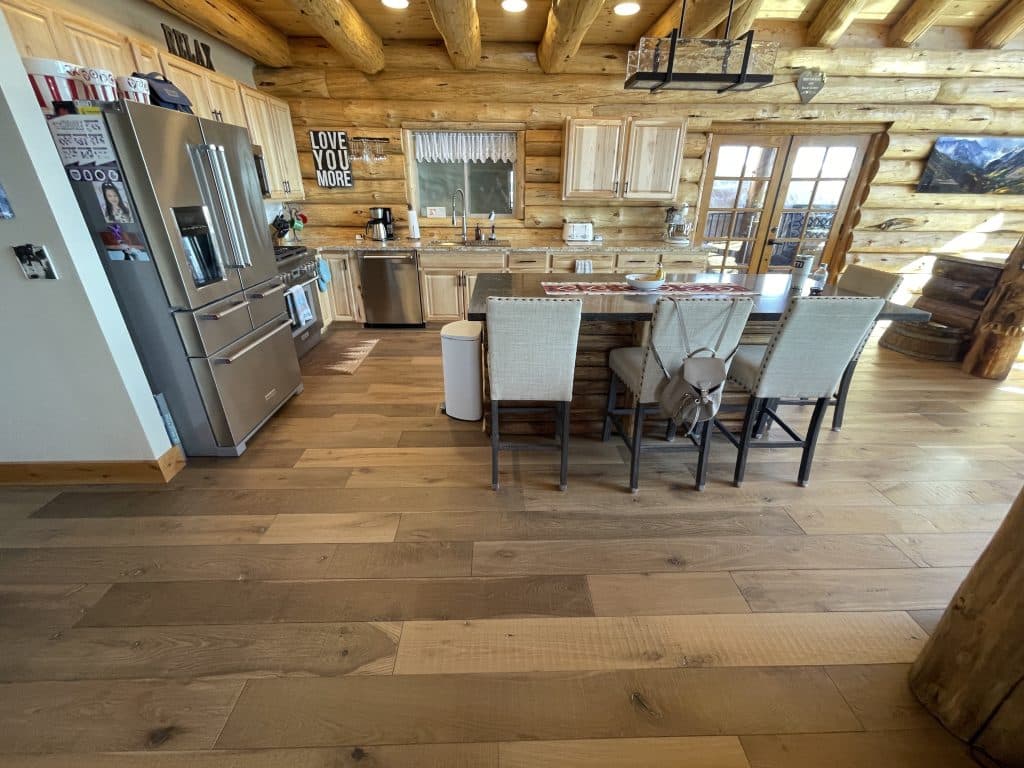 Wide plank hardwood floor installed in a kitchen. Here a NWFA certified inspector examined the floor for splinters.