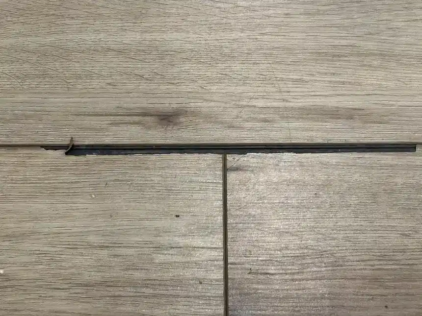Chipped luxury vinyl plank edge documented in the field